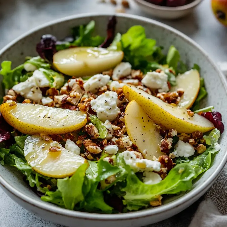 A bowl of salad with pear, feta, and lettuce.