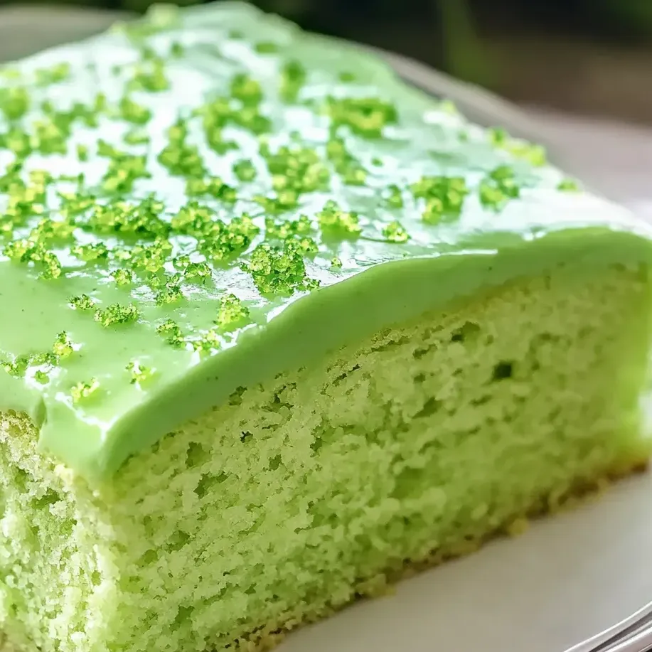 A slice of green cake with lime frosting.