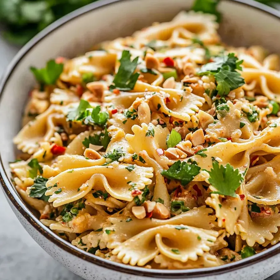 A bowl of pasta with vegetables and nuts.