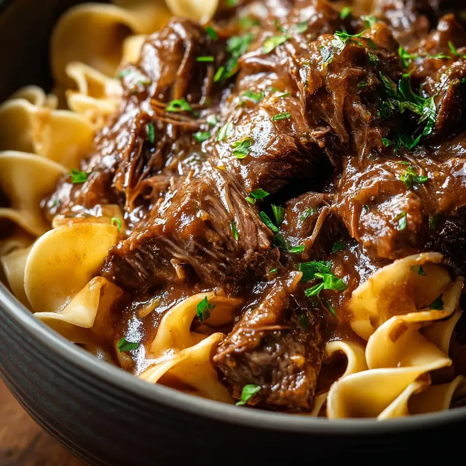 A bowl of pasta with meat and sauce.