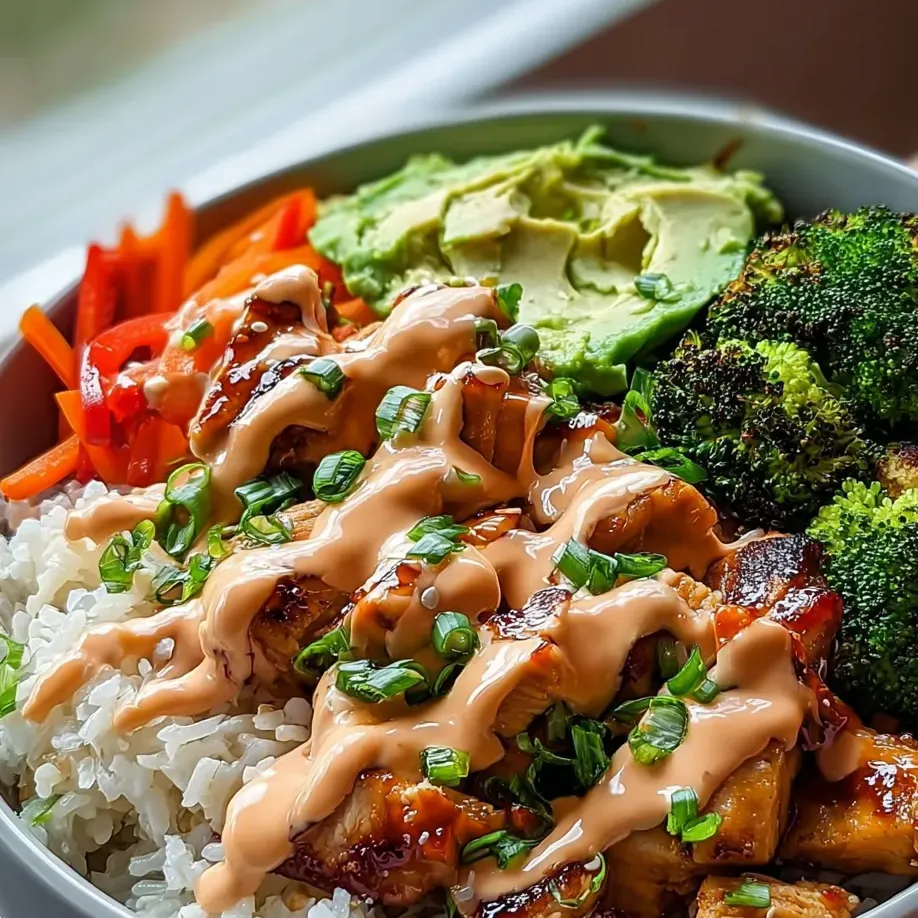 A bowl of food with rice, carrots, broccoli, and other vegetables.