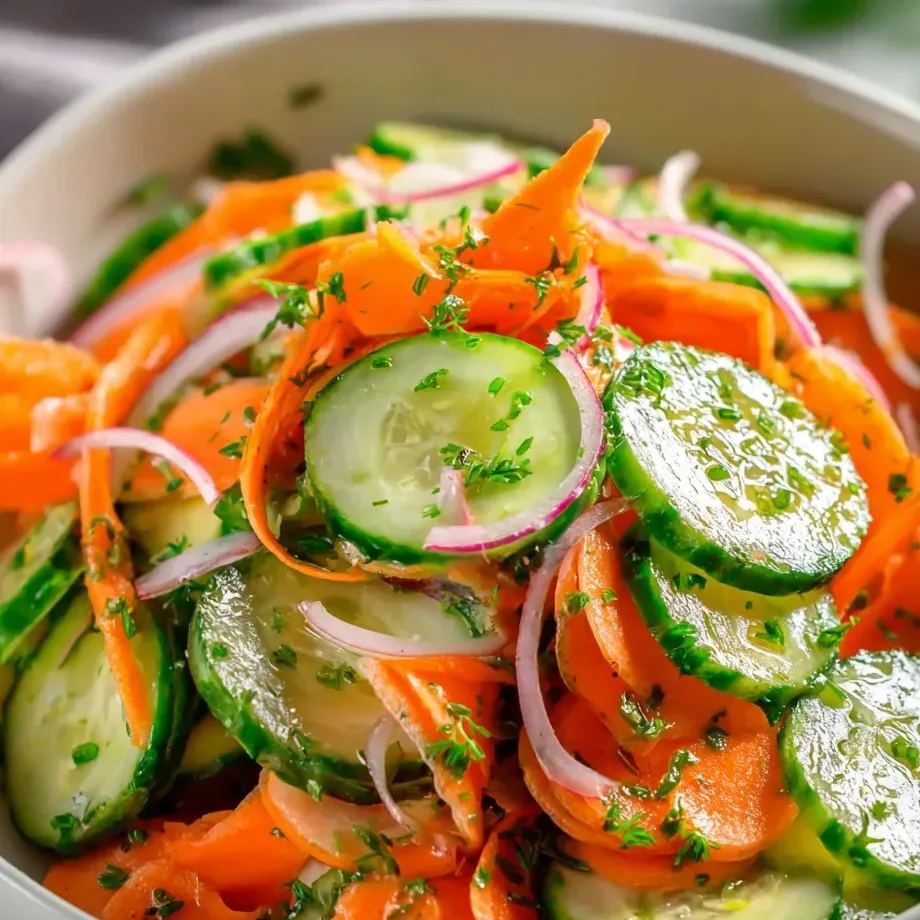 A bowl of vegetables including carrots, cucumbers, and onions.