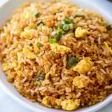A bowl of rice with eggs and vegetables.