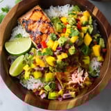 A bowl of grilled salmon with mango salsa.