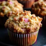 A cupcake with a slice of onion on top.