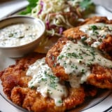 A plate of chicken fried steak with country gravy.