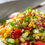 A bowl of food with corn and tomatoes.
