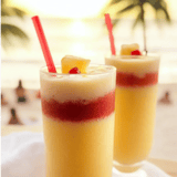 Two glasses of pineapple juice with red straws.