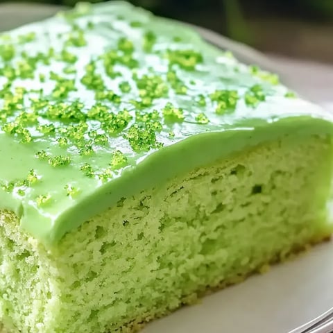 A slice of green cake with lime frosting.