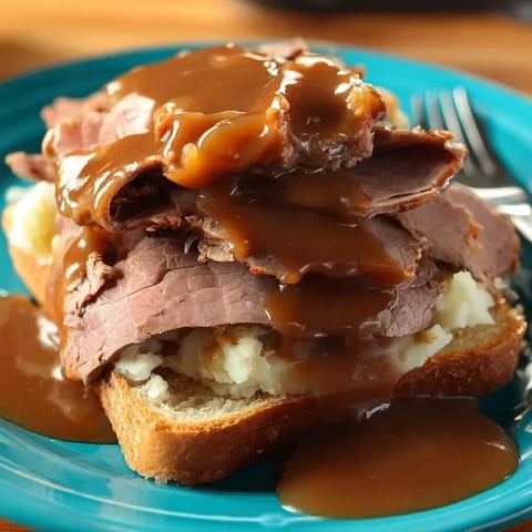 A plate of meat with gravy on it.