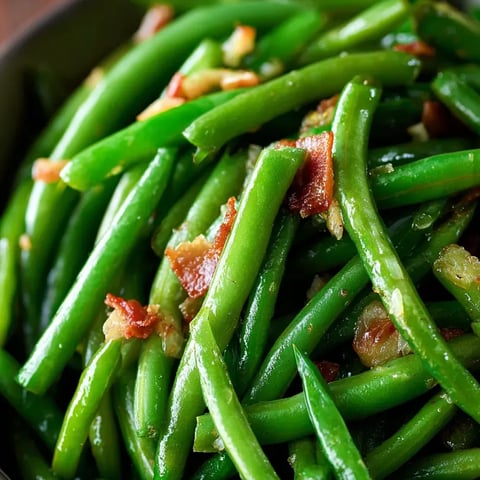 A bowl of green beans with bacon.