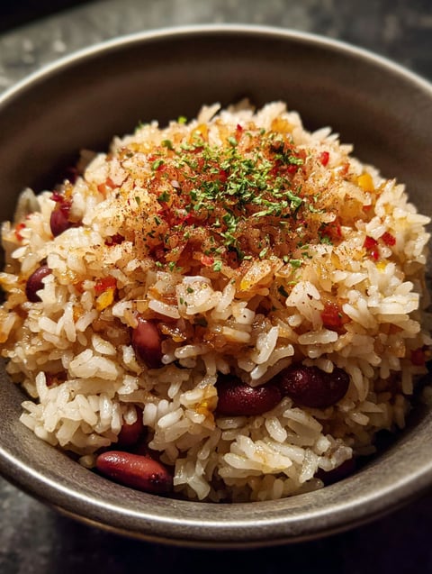 A bowl of rice with beans and spices.